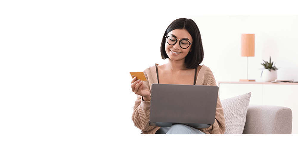 girl looking at laptop with debit card